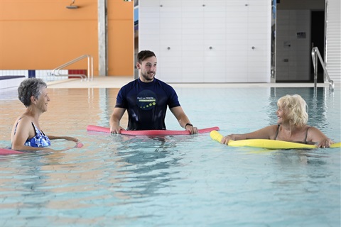 25m-pool-physiotherapy-with-noodles-smiling-physio-standing.jpg